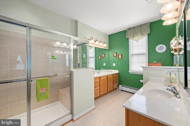 bathroom with tile patterned flooring, vanity, a shower with door, and a baseboard heating unit