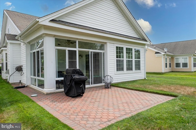 rear view of house with a yard, a patio, and a sunroom