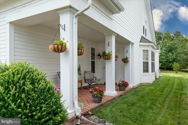 property entrance featuring a lawn and a porch