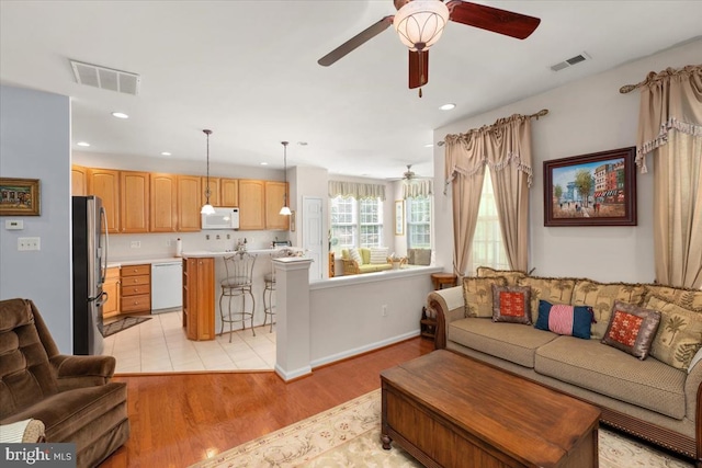 living room with light wood-type flooring and ceiling fan