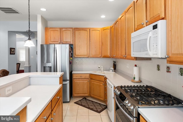 kitchen featuring decorative backsplash, appliances with stainless steel finishes, sink, light tile patterned floors, and hanging light fixtures