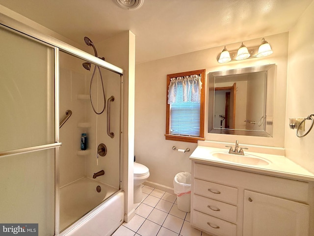 full bathroom featuring tile patterned flooring, vanity, combined bath / shower with glass door, and toilet