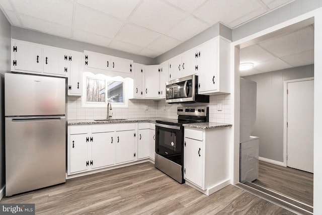 kitchen with wood-type flooring, white cabinetry, sink, and appliances with stainless steel finishes