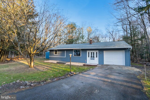 single story home featuring a garage and a front lawn