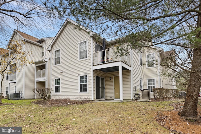 view of front of home with a front lawn, a balcony, and cooling unit