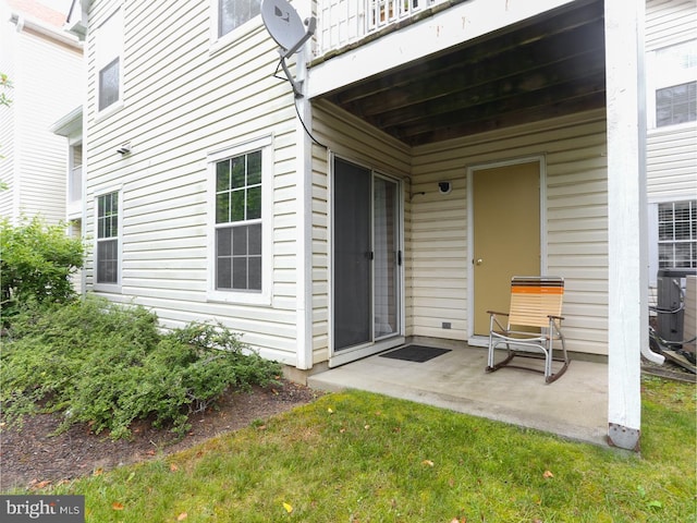 doorway to property with cooling unit, a balcony, a yard, and a patio