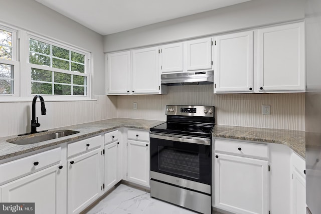 kitchen with white cabinetry, light stone countertops, stainless steel electric range oven, and sink