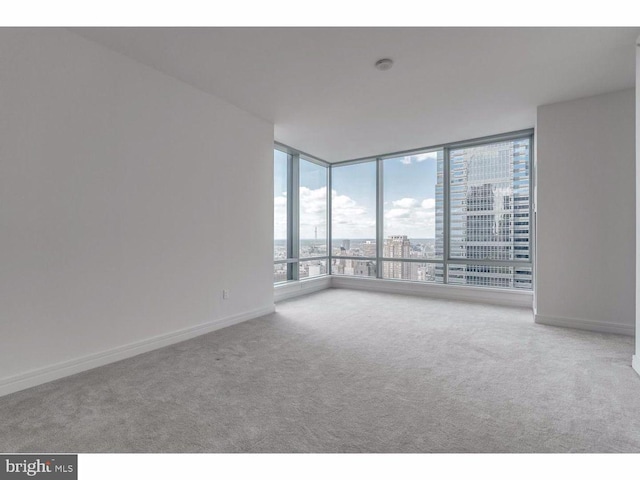 1414 S Penn Sq S Unit 45Gh, Philadelphia, PA 19102 - spare room with carpet, baseboards, a wall of windows, and a city view