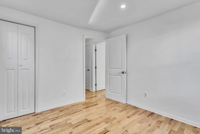 unfurnished bedroom featuring light hardwood / wood-style floors and a closet