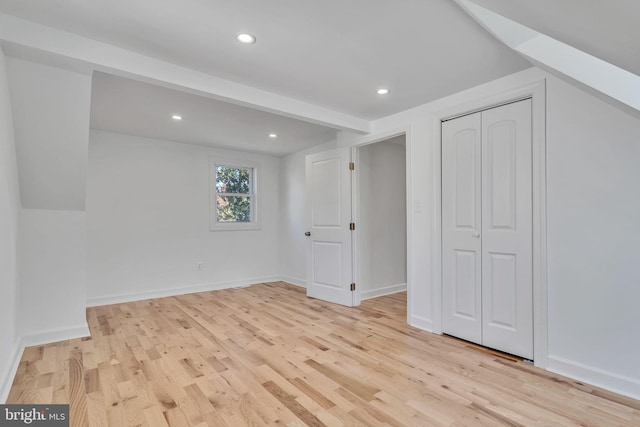 additional living space with light hardwood / wood-style flooring