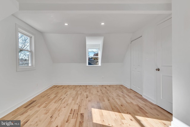 bonus room featuring light wood-type flooring and vaulted ceiling