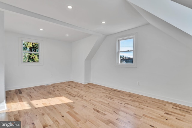 bonus room featuring light hardwood / wood-style floors, lofted ceiling, and a wealth of natural light