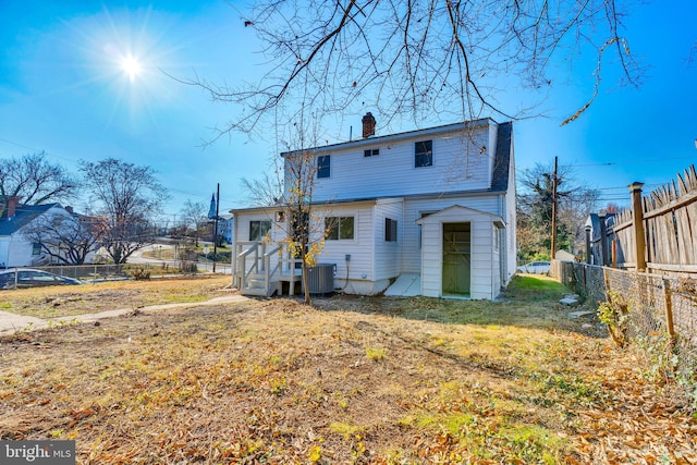 back of house with central AC and a yard