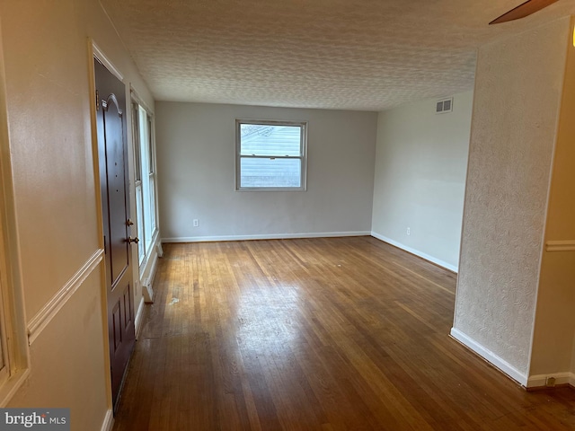 unfurnished room featuring wood-type flooring and a textured ceiling