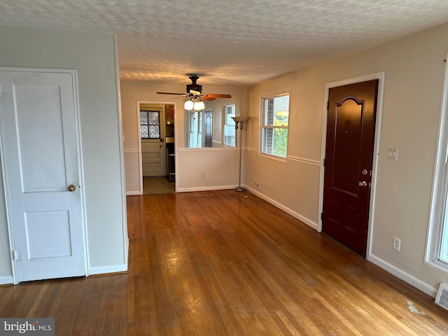 spare room with ceiling fan, a textured ceiling, and hardwood / wood-style flooring