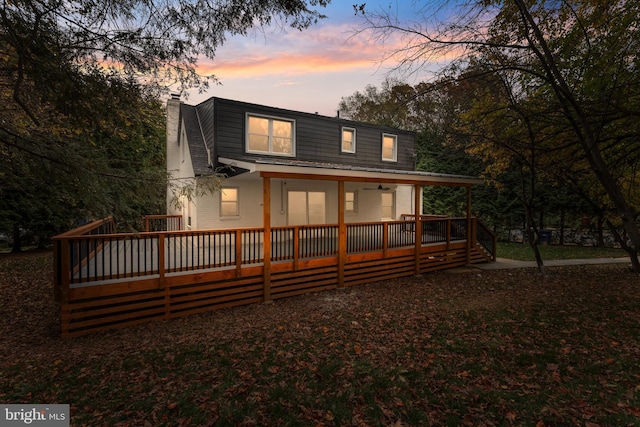 back house at dusk with a deck