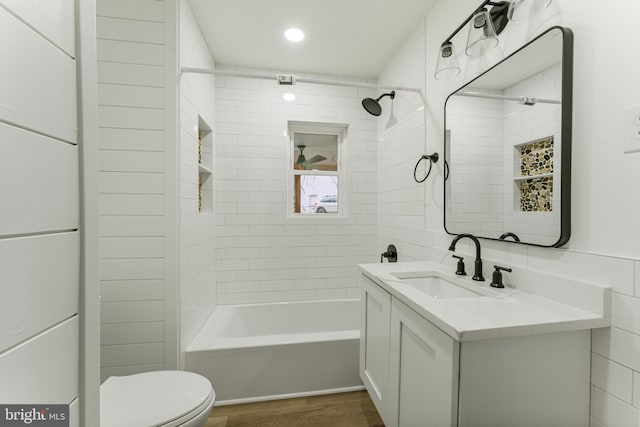 full bathroom with vanity, toilet, wood-type flooring, and tiled shower / bath combo