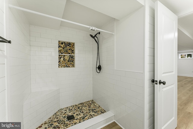 bathroom featuring a tile shower and hardwood / wood-style floors