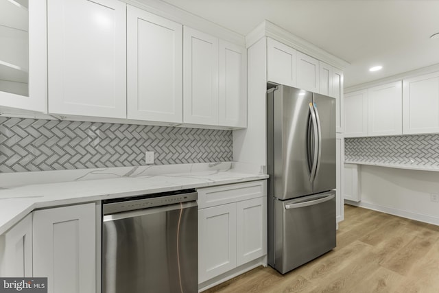 kitchen featuring white cabinets, tasteful backsplash, light hardwood / wood-style floors, light stone counters, and stainless steel appliances