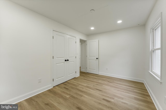 unfurnished bedroom featuring light hardwood / wood-style flooring and multiple windows