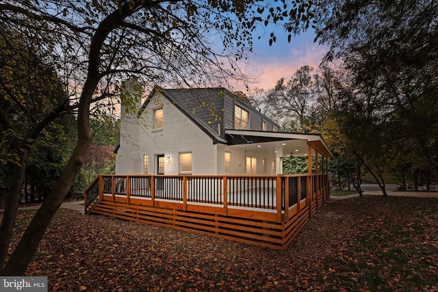 back house at dusk with a deck