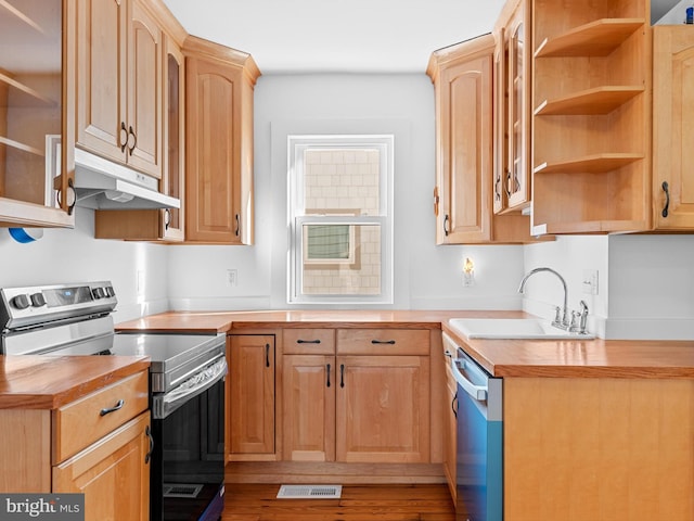 108 Philadelphia St Unit B, Rehoboth Beach, DE 19971 - kitchen with stainless steel appliances, under cabinet range hood, butcher block counters, light brown cabinets, and open shelves