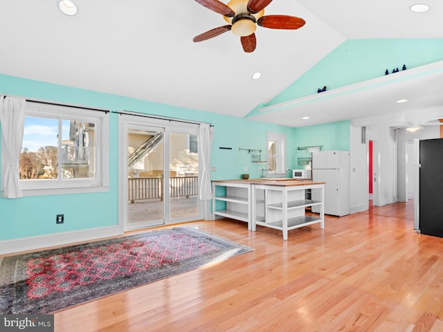 living room with wood-type flooring, ceiling fan, and lofted ceiling