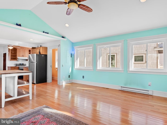 kitchen with lofted ceiling, light wood-type flooring, stainless steel appliances, and a baseboard heating unit