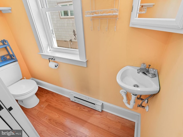 bathroom featuring sink, toilet, a baseboard radiator, and hardwood / wood-style flooring