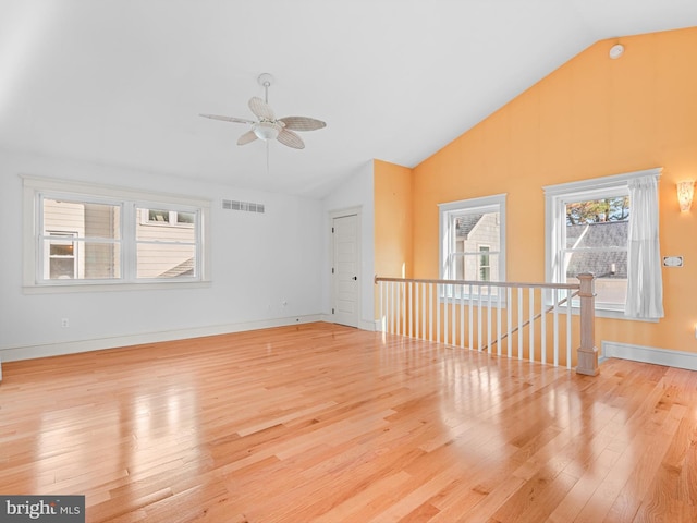 empty room featuring ceiling fan, high vaulted ceiling, and light wood-type flooring