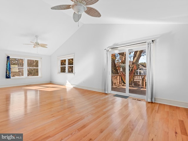 unfurnished living room with a wealth of natural light, light hardwood / wood-style flooring, ceiling fan, and vaulted ceiling