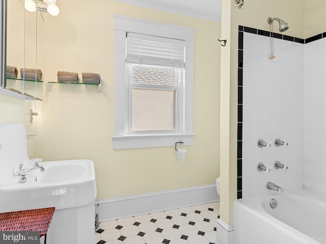 bathroom featuring tiled shower / bath combo and toilet