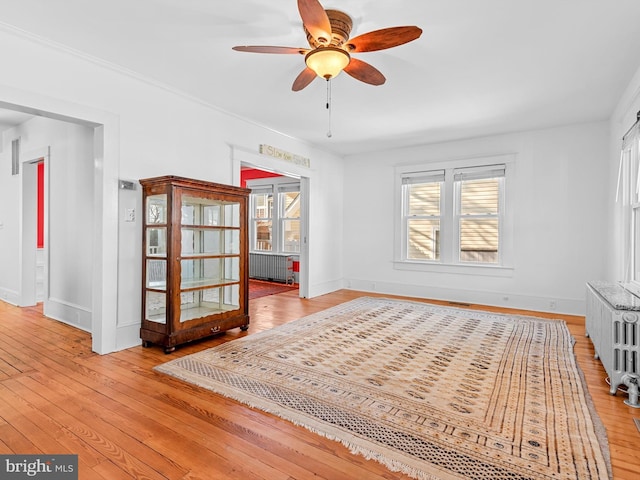 unfurnished room with radiator, ceiling fan, and light hardwood / wood-style flooring