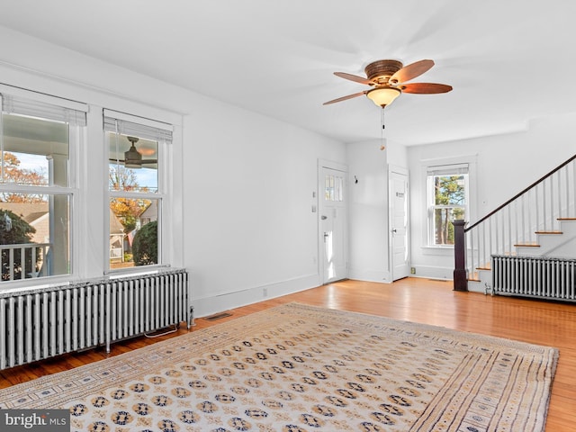 foyer featuring ceiling fan, radiator heating unit, and hardwood / wood-style flooring