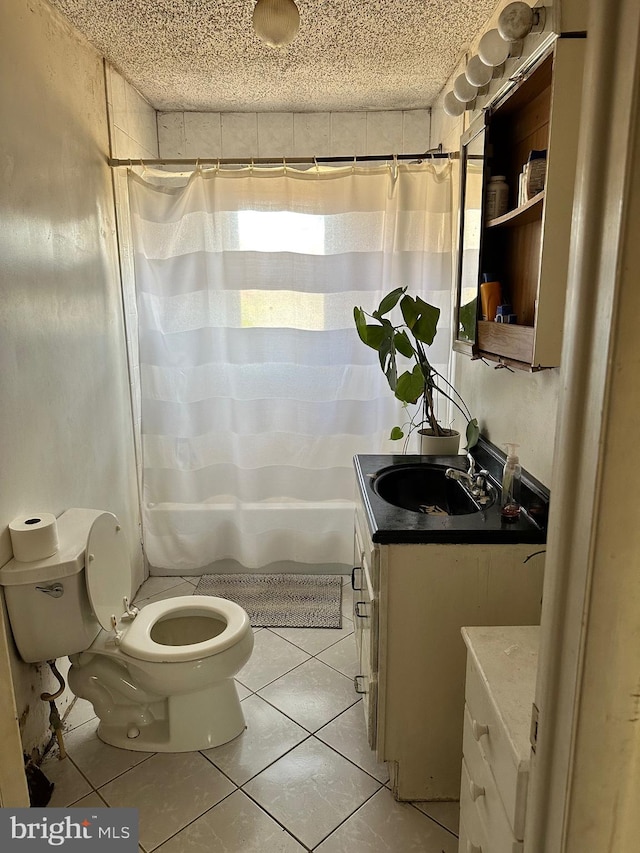 bathroom featuring tile patterned flooring, a textured ceiling, vanity, and toilet