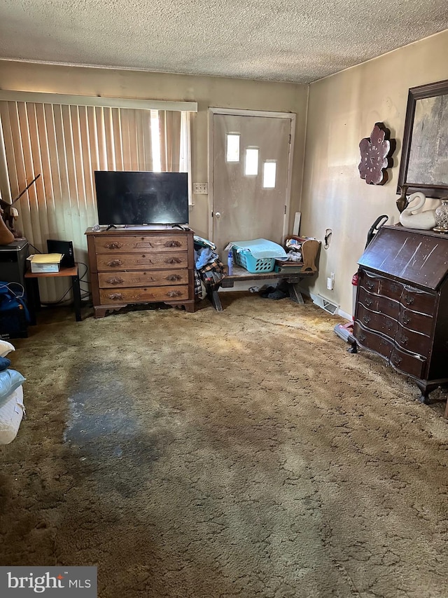 bedroom featuring a textured ceiling and carpet floors