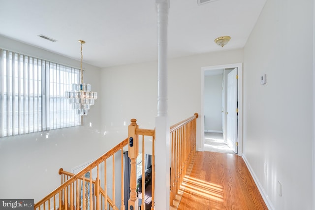 hallway featuring a notable chandelier and hardwood / wood-style flooring