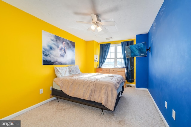 carpeted bedroom featuring ceiling fan and a textured ceiling