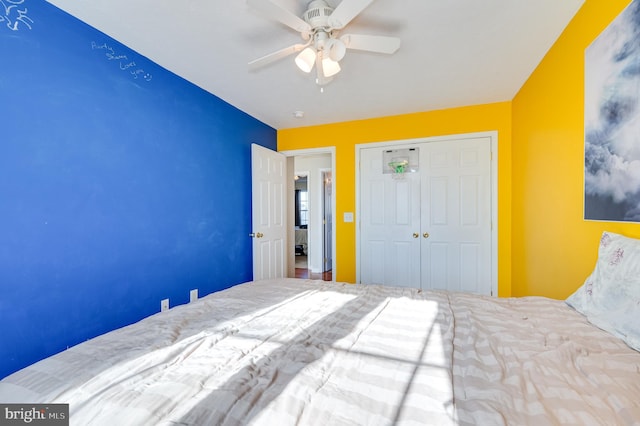 unfurnished bedroom featuring ceiling fan and a closet