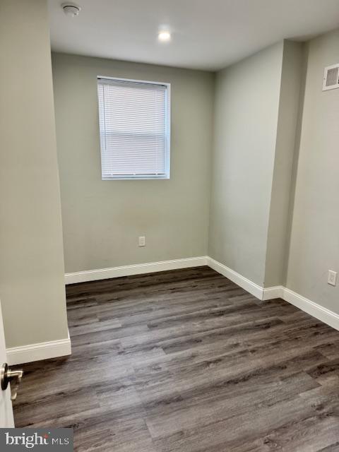 spare room featuring dark wood-type flooring