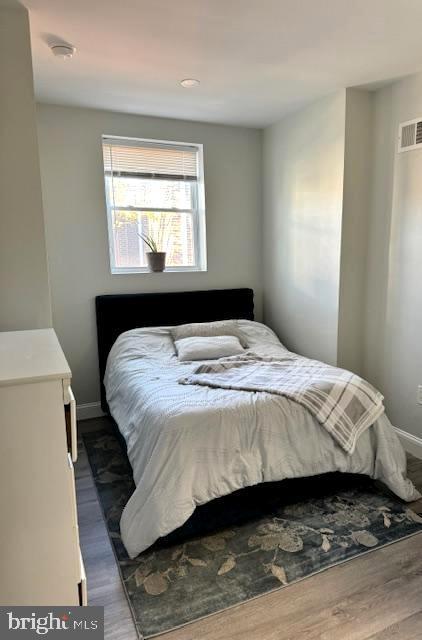 bedroom with dark hardwood / wood-style floors