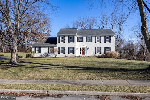 colonial-style house featuring a front lawn