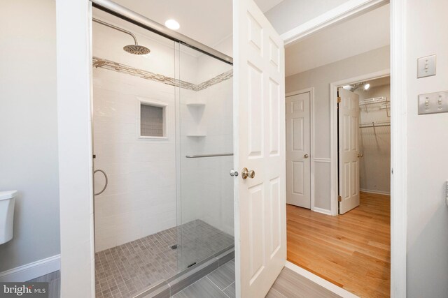 bathroom with hardwood / wood-style floors and an enclosed shower