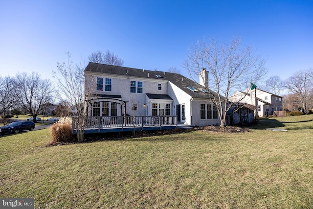 rear view of property featuring a yard and a wooden deck