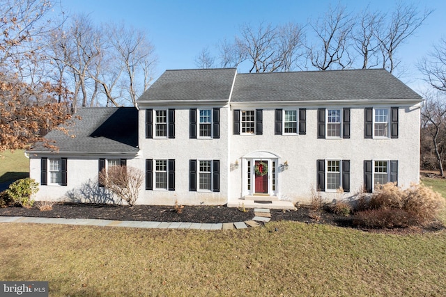 colonial home with a front lawn