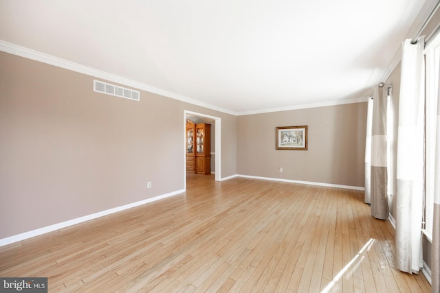 empty room with light wood-type flooring and ornamental molding