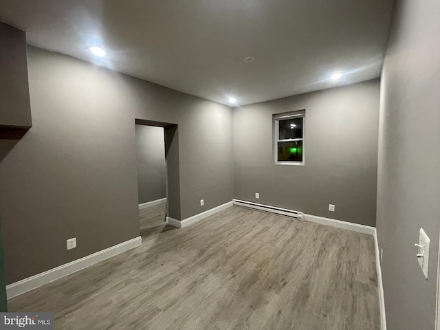 basement featuring hardwood / wood-style flooring and baseboard heating