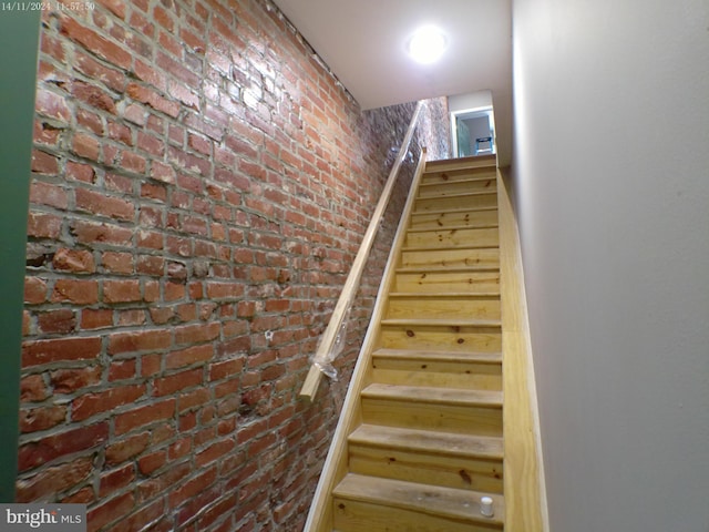 stairs featuring brick wall