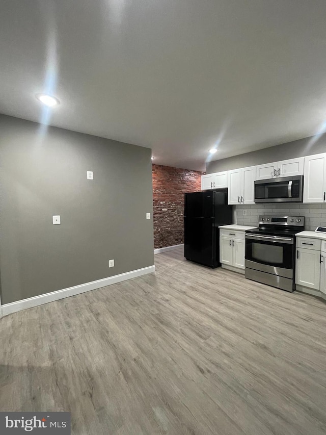 kitchen featuring decorative backsplash, stainless steel appliances, white cabinetry, and light hardwood / wood-style floors