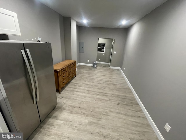 kitchen with electric panel, light wood-type flooring, and stainless steel refrigerator